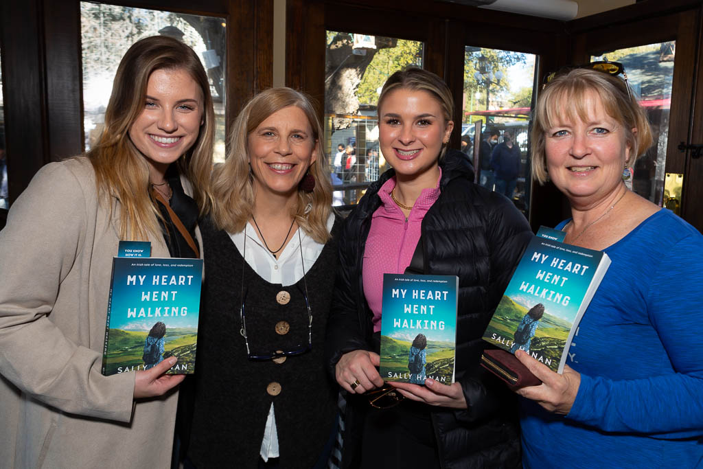 Four women holding book